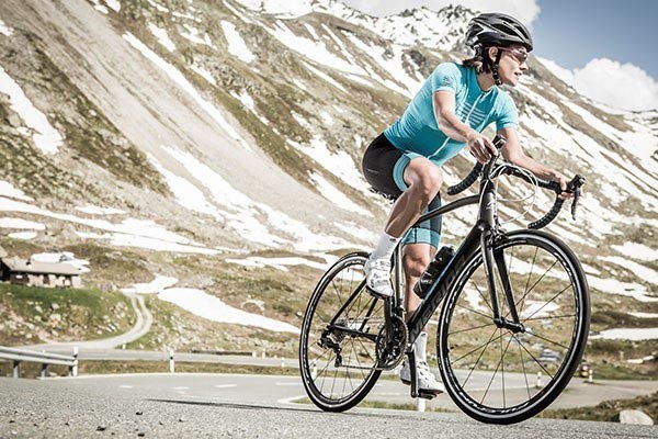 Female road cyclist in the alps